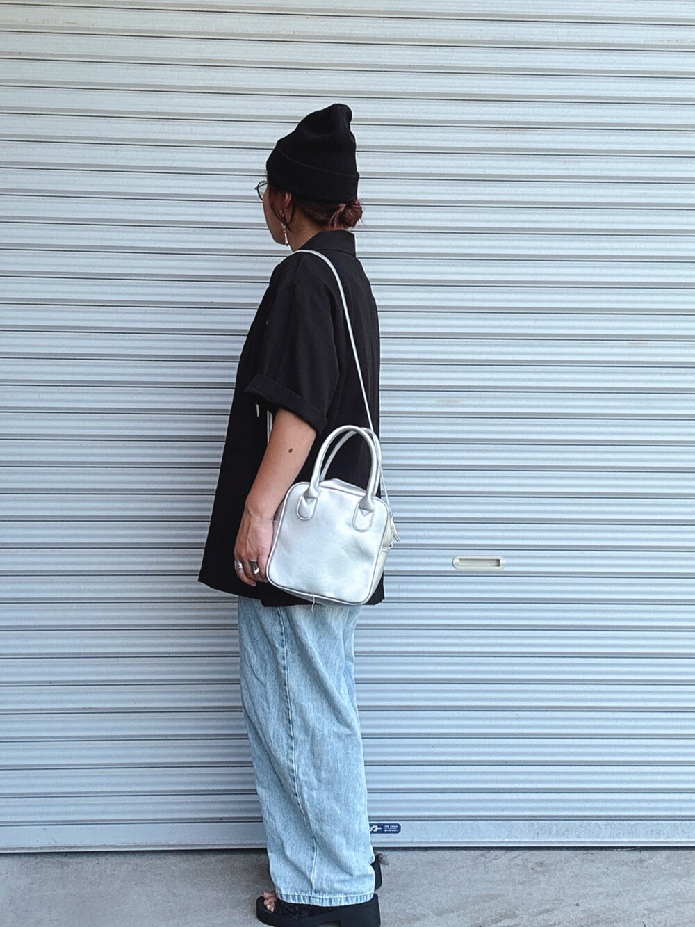 ブラック系のテーラードジャケット、レッド系のTシャツ/カットソー、ブルー系のデニムパンツを着用したレディースの夏コーディネートの2枚目の写真