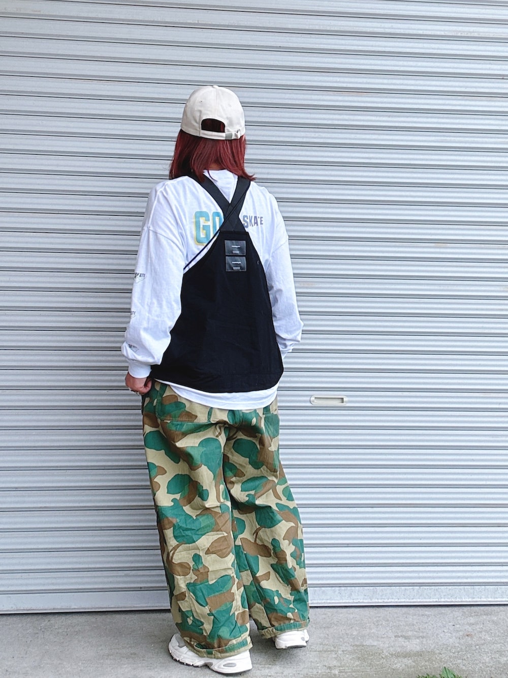 シルバー系のショルダーバッグ、ホワイト系のTシャツ/カットソー、ブラック系のベストを着用したレディースの春コーディネートの2枚目の写真