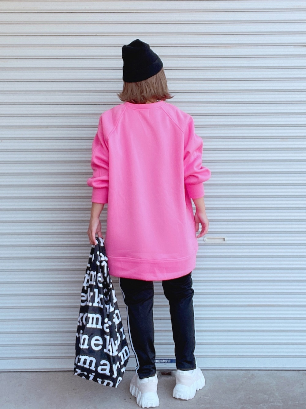 ピンク系のスウェット、ブラック系のその他パンツ、ブラック系のエコバッグ/サブバッグを着用したレディースの冬コーディネートの2枚目の写真