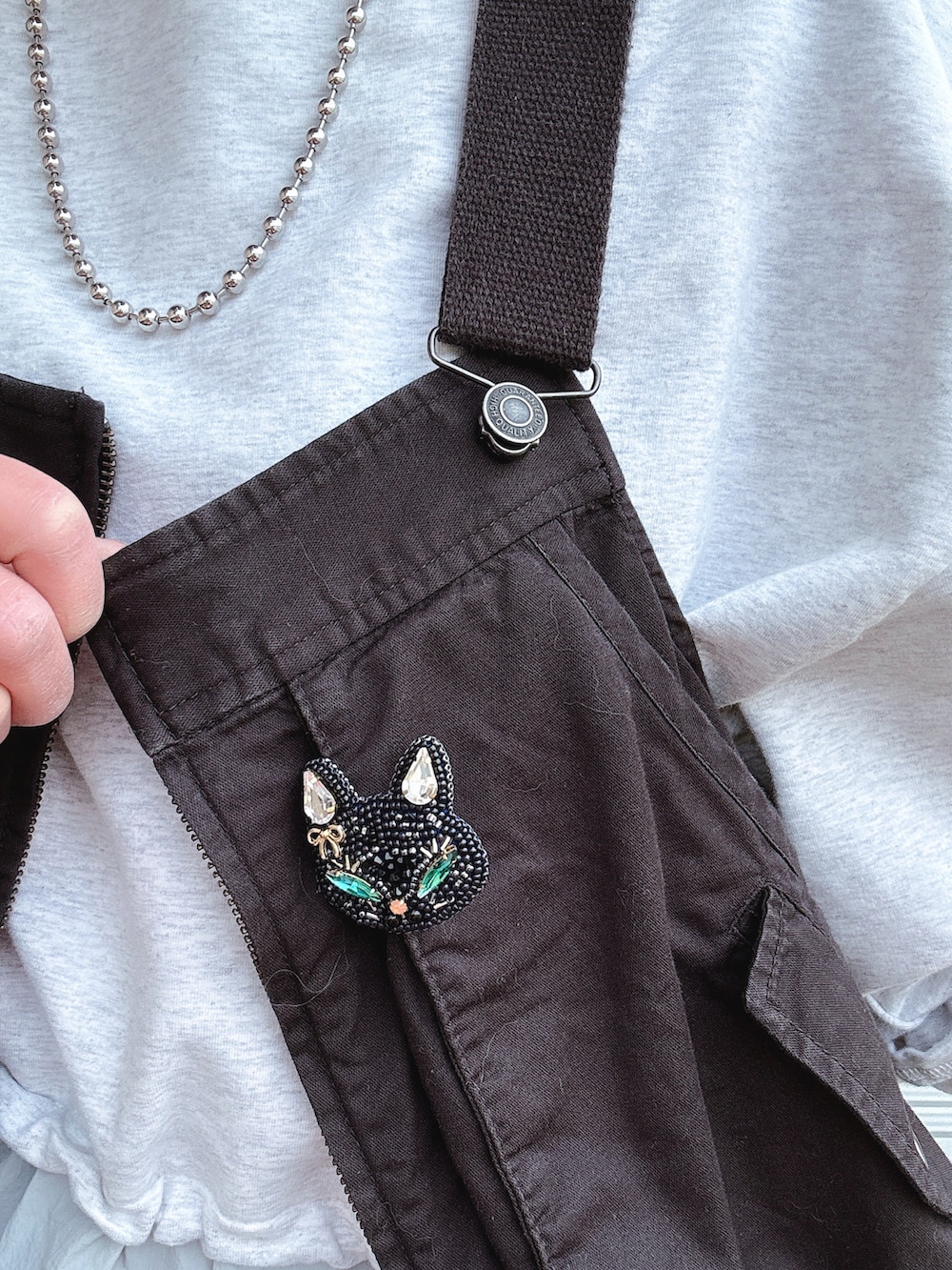 ブラック系のトップス、グレー系のトップス、グレー系のパンツを着用したレディースの春コーディネートの3枚目の写真