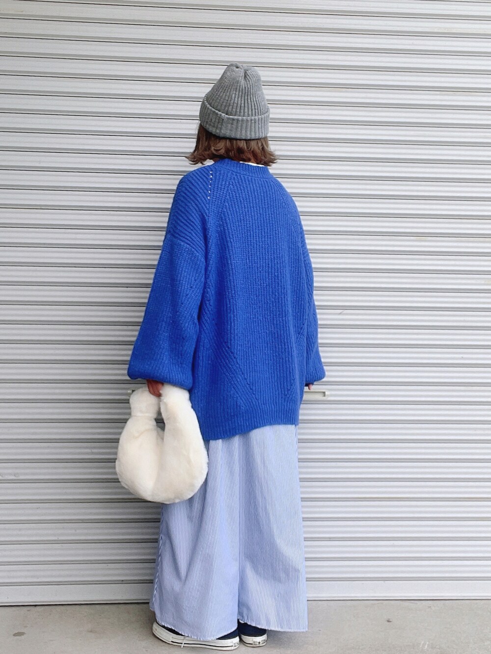 ブルー系のニット/セーター、ブルー系のワンピース、ホワイト系のバッグを着用したレディースの秋コーディネートの2枚目の写真