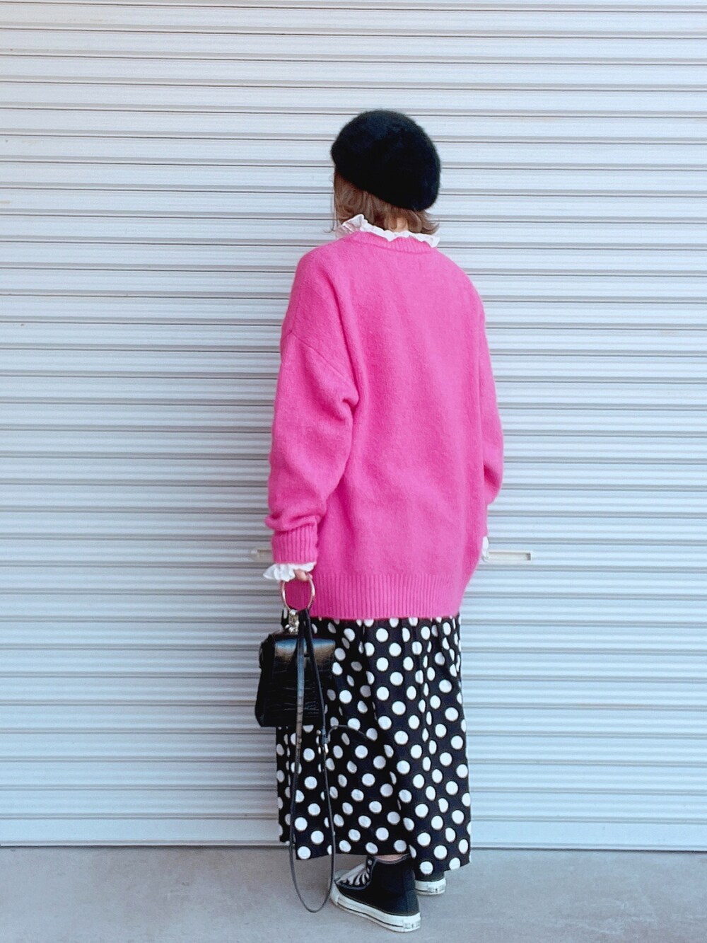 ピンク系のニット/セーター、ホワイト系のシャツ/ブラウス、ブラック系のスカートを着用したレディースの冬コーディネートの2枚目の写真