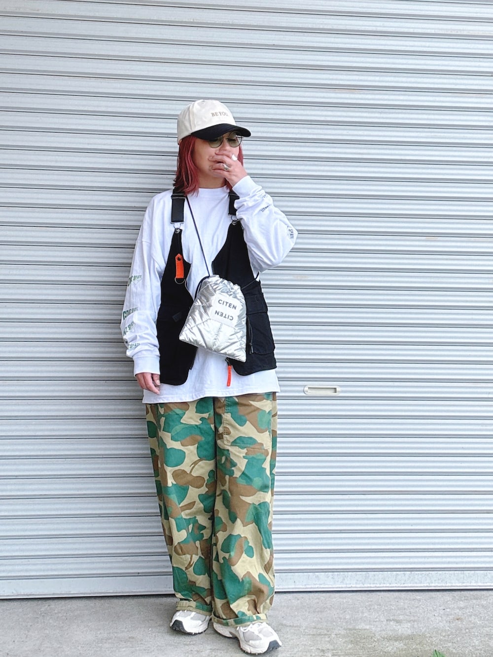 シルバー系のショルダーバッグ、ホワイト系のTシャツ/カットソー、ブラック系のベストを着用したレディースの春コーディネートの3枚目の写真