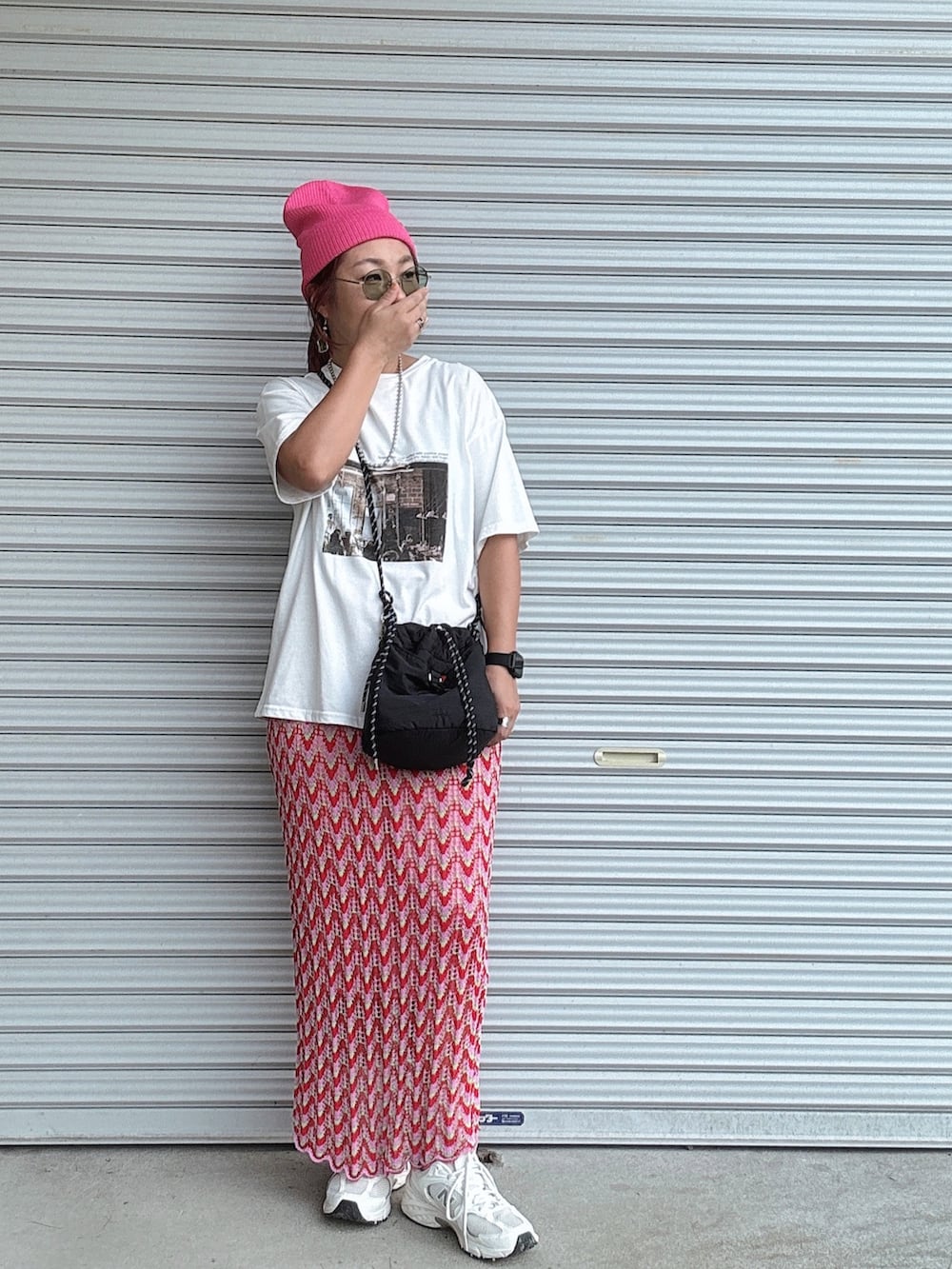 ホワイト系のTシャツ/カットソー、ピンク系のスカート、ブラック系のショルダーバッグを着用したレディースの秋コーディネートの2枚目の写真