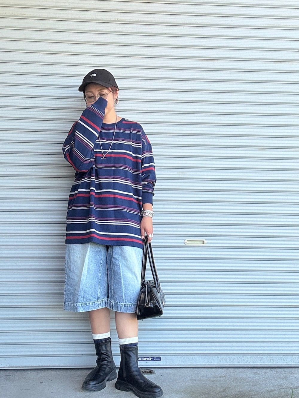 ブルー系のデニムパンツ、ブラック系のブーツ、ブルー系のTシャツ/カットソーを着用したレディースの秋コーディネートの2枚目の写真