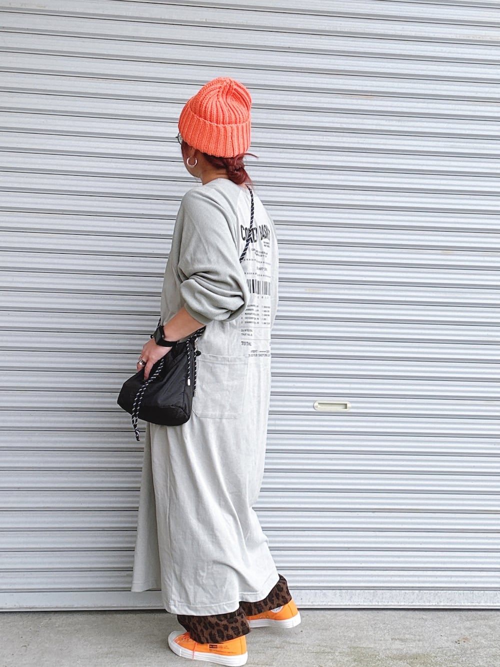 グレー系のその他パンツ、ブラック系のショルダーバッグ、オレンジ系のスニーカーを着用したレディースの春コーディネートの2枚目の写真