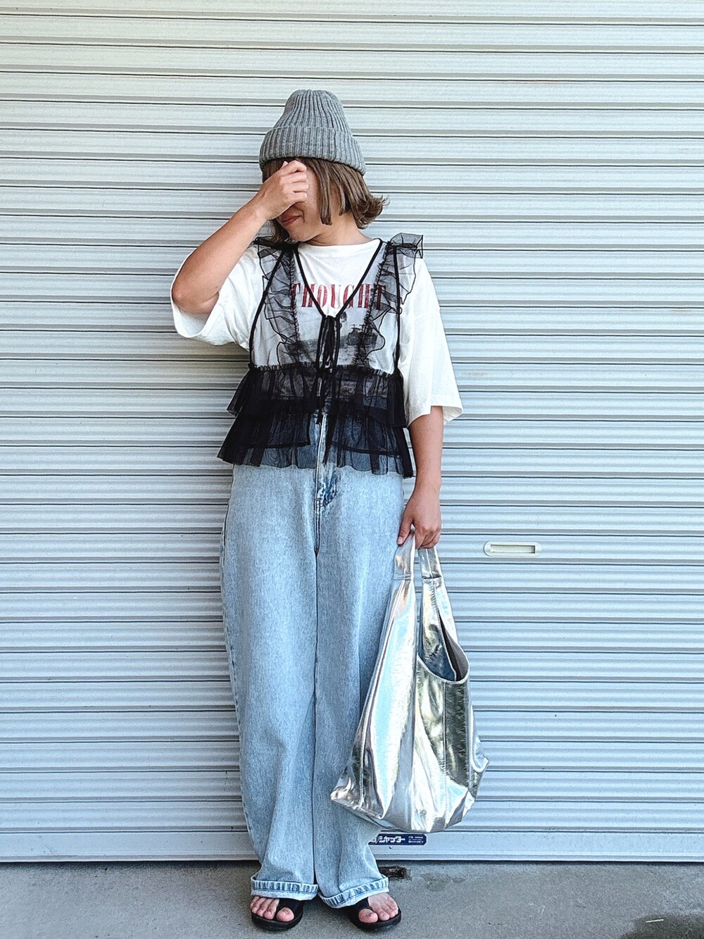 ブラック系のベスト、ホワイト系のTシャツ/カットソー、ブルー系のデニムパンツを着用したレディースの夏コーディネートの2枚目の写真