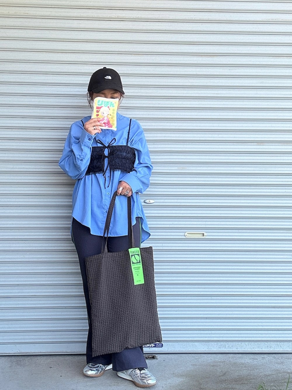 オレンジ系のエコバッグ/サブバッグ、シルバー系のスニーカー、ブラック系のその他トップスを着用したレディースの秋コーディネートの2枚目の写真