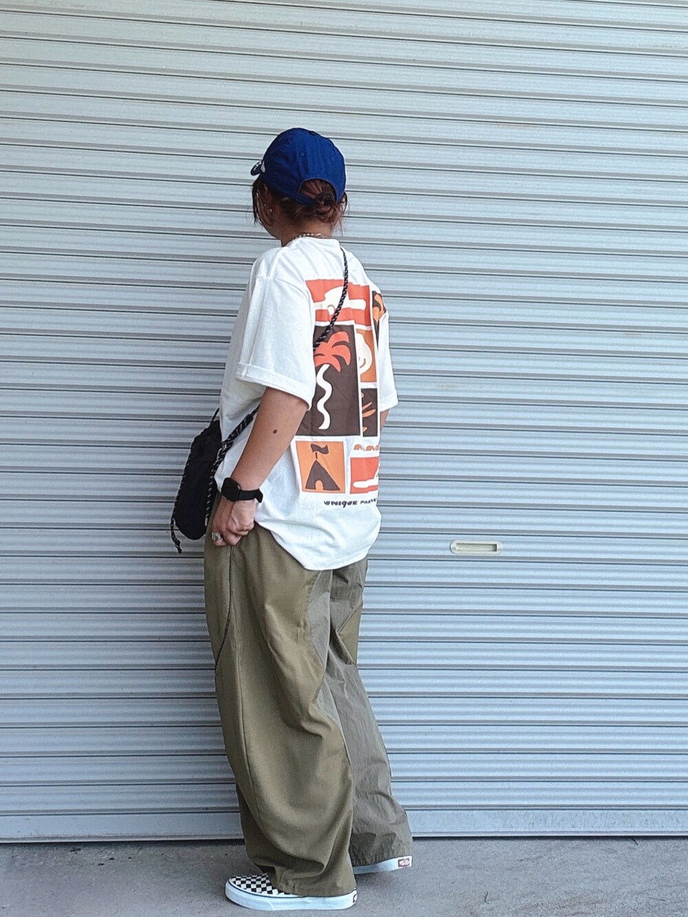 ブラック系のスニーカー、ブラック系のショルダーバッグ、ホワイト系のトップスを着用したレディースの秋コーディネートの2枚目の写真