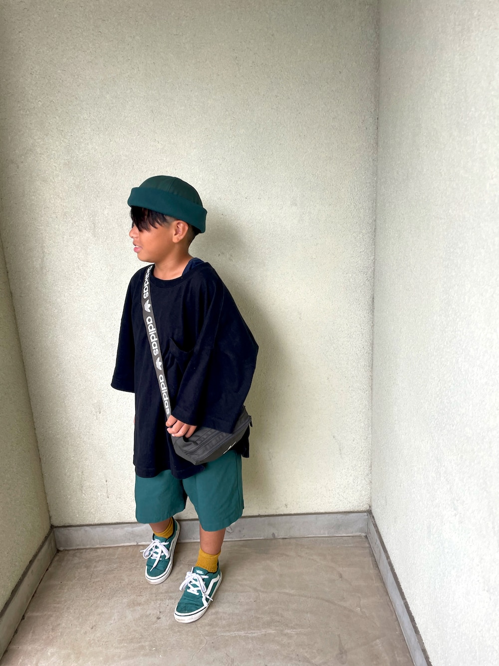 グリーン系のスニーカー、ブラック系のTシャツ/カットソー、シルバー系のバッグを着用したキッズの夏コーディネートの2枚目の写真