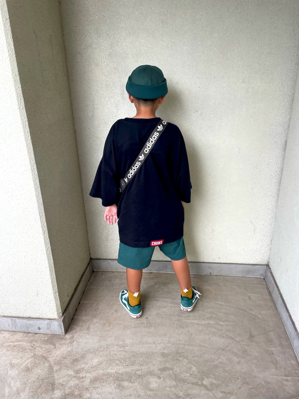 グリーン系のスニーカー、ブラック系のTシャツ/カットソー、シルバー系のバッグを着用したキッズの夏コーディネートの3枚目の写真