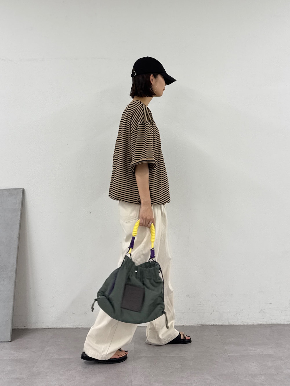ベージュ系のTシャツ/カットソー、ホワイト系のデニムパンツ、グリーン系のトートバッグを着用したレディースの夏コーディネートの3枚目の写真