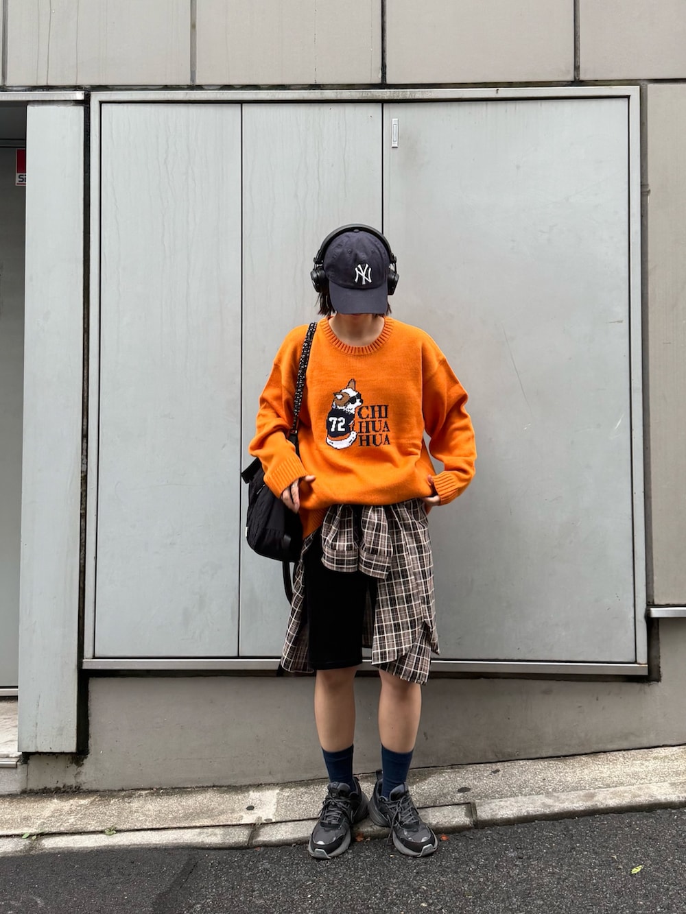 オレンジ系のニット/セーター、ブラック系のトートバッグ、ブラウン系のシャツ/ブラウスを着用したレディースの秋コーディネートの3枚目の写真