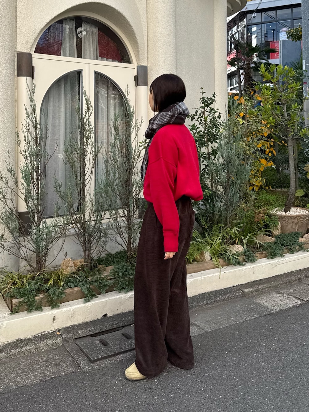 ブラウン系のスラックス、レッド系のニット/セーターを着用したレディースの秋コーディネートの2枚目の写真