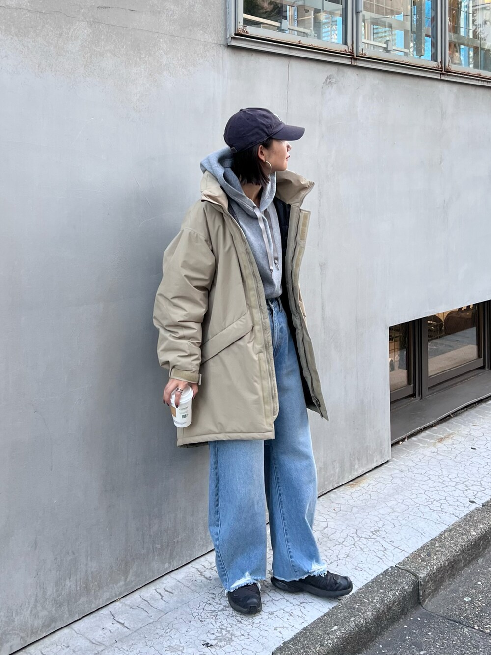 ブルー系のデニムパンツ、ベージュ系のダウンジャケット/コート、グレー系のパーカーを着用したレディースの秋コーディネートの2枚目の写真