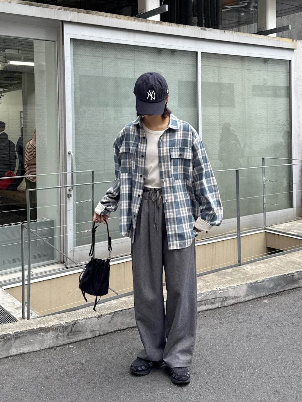 ブルー系のシャツ/ブラウス、グレー系のスラックス、ブラック系のショルダーバッグを着用したレディースの秋コーディネートの2枚目の写真