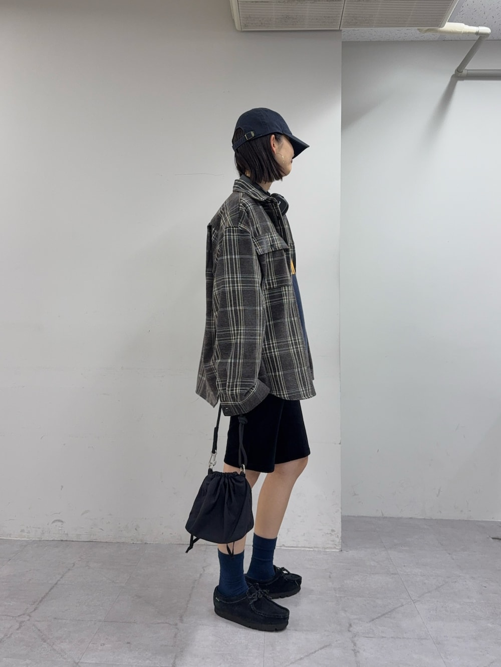 ブルー系のスウェット、ブラック系のショルダーバッグ、ブラウン系のシャツ/ブラウスを着用したレディースの秋コーディネートの2枚目の写真