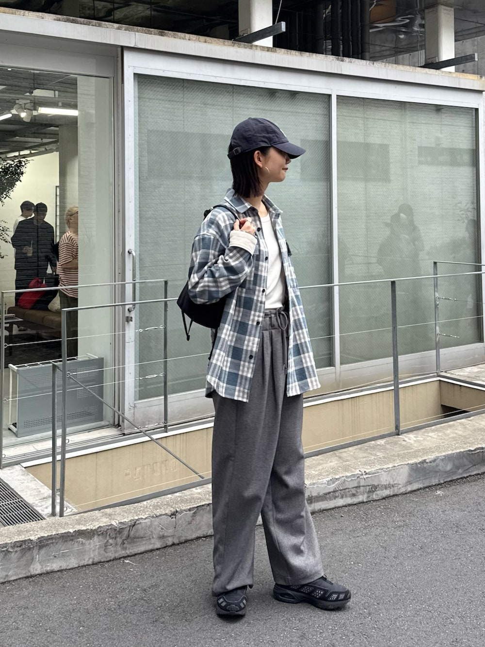 ブルー系のシャツ/ブラウス、グレー系のスラックス、ブラック系のショルダーバッグを着用したレディースの秋コーディネートの3枚目の写真