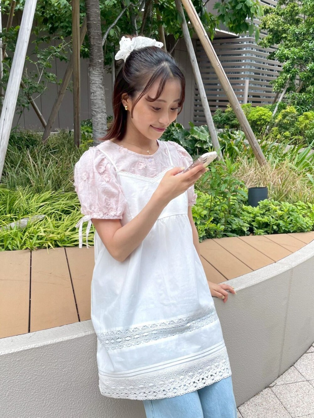 ホワイト系のショルダーバッグ、ブルー系のデニムパンツ、ピンク系のシャツ/ブラウスを着用したレディースの春コーディネートの2枚目の写真