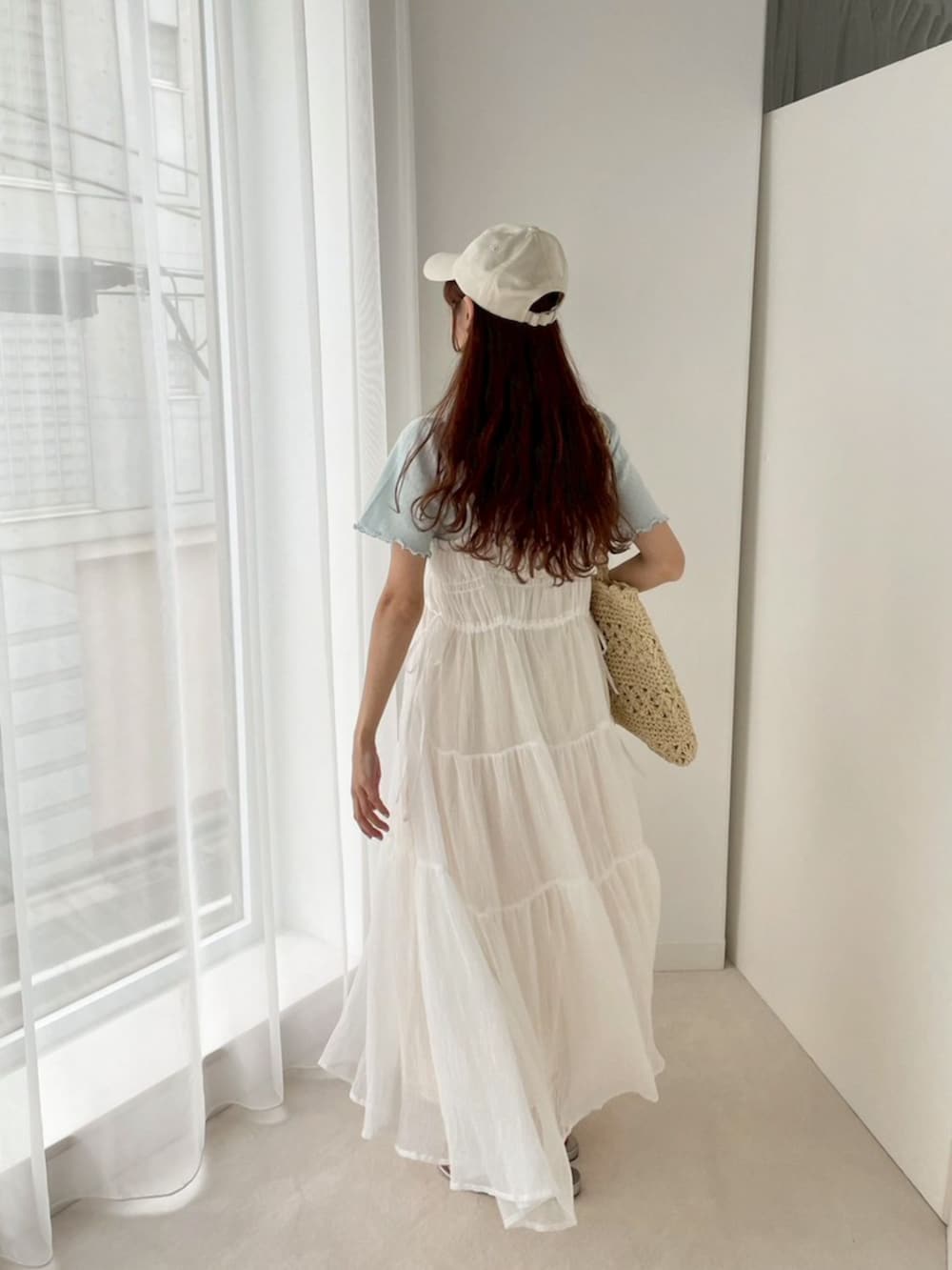 ホワイト系のワンピース、ブルー系のTシャツ/カットソー、ベージュ系のトートバッグを着用したレディースの春コーディネートの2枚目の写真