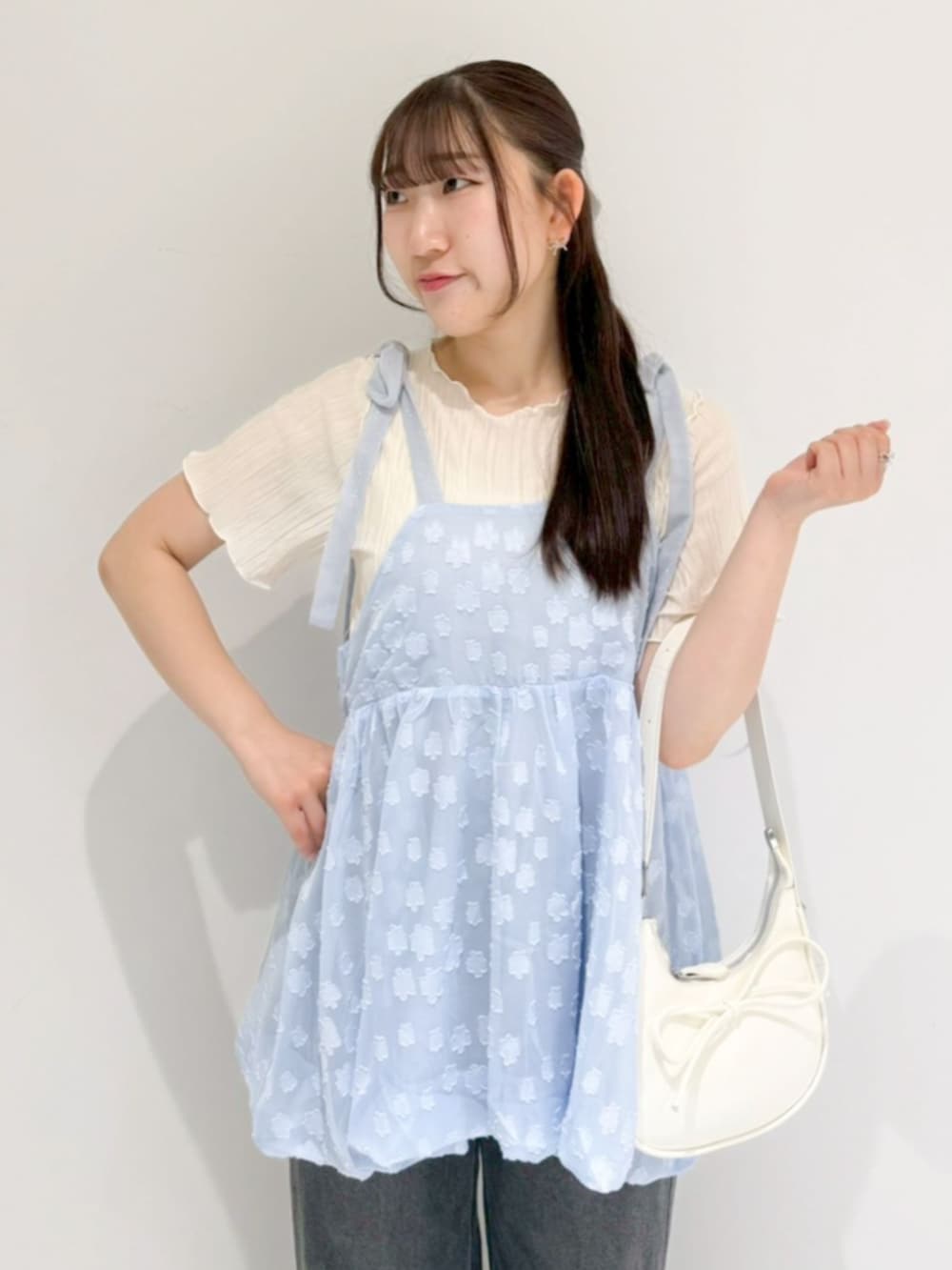 ホワイト系のTシャツ/カットソー、ブラック系のデニムパンツ、ホワイト系のショルダーバッグを着用したレディースの春コーディネートの2枚目の写真