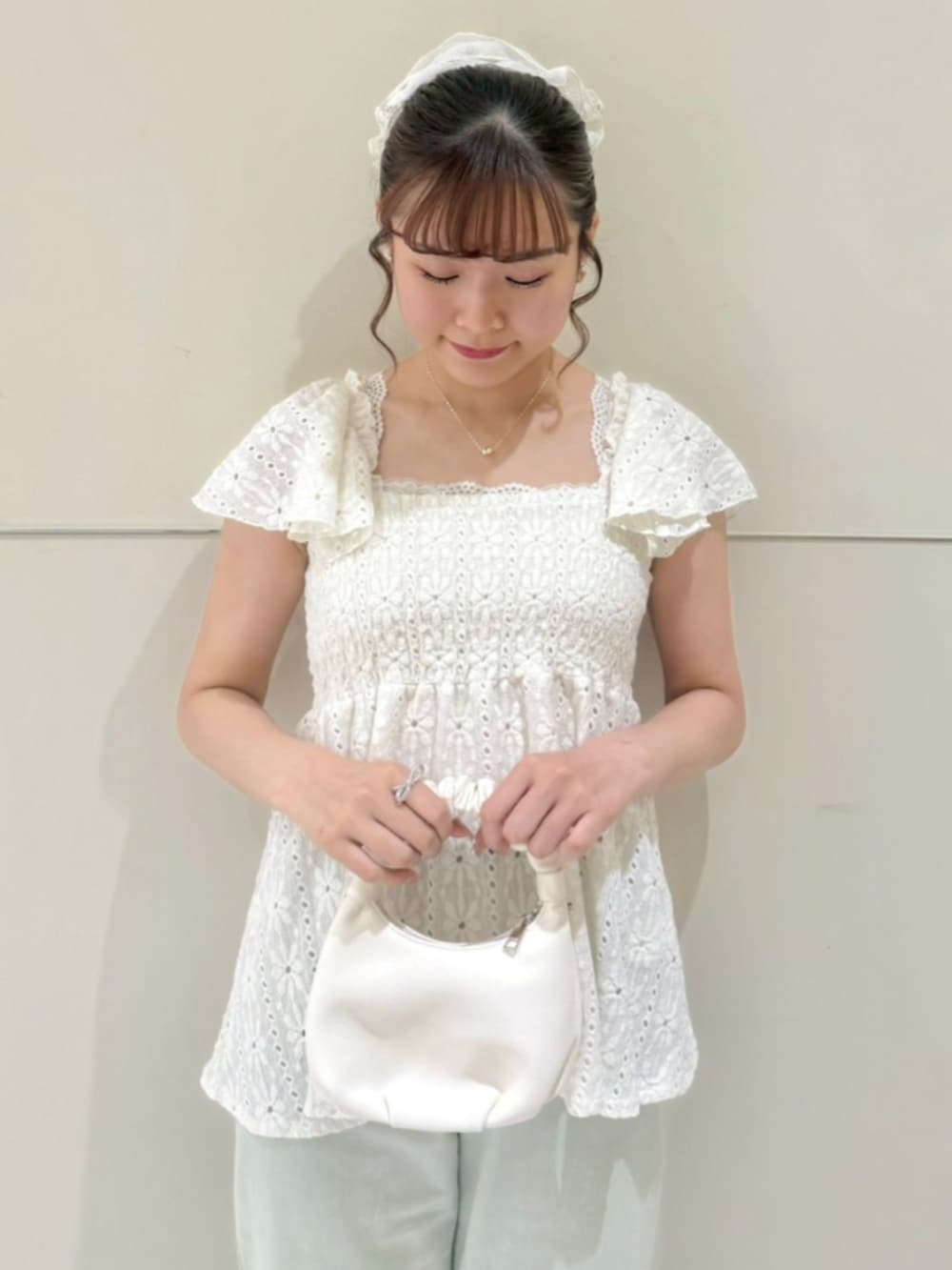 グリーン系のデニムパンツ、ホワイト系のショルダーバッグ、ホワイト系のシャツ/ブラウスを着用したレディースの春コーディネートの2枚目の写真