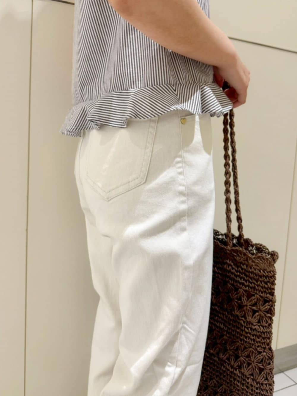 ブラウン系のかごバッグ、ブラウン系のシャツ/ブラウス、ホワイト系のデニムパンツを着用したレディースの夏コーディネートの4枚目の写真