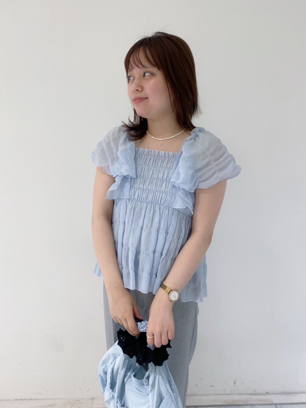 ブルー系のショルダーバッグ、ブルー系のシャツ/ブラウス、ブラック系のその他パンツを着用したレディースの夏コーディネートの2枚目の写真