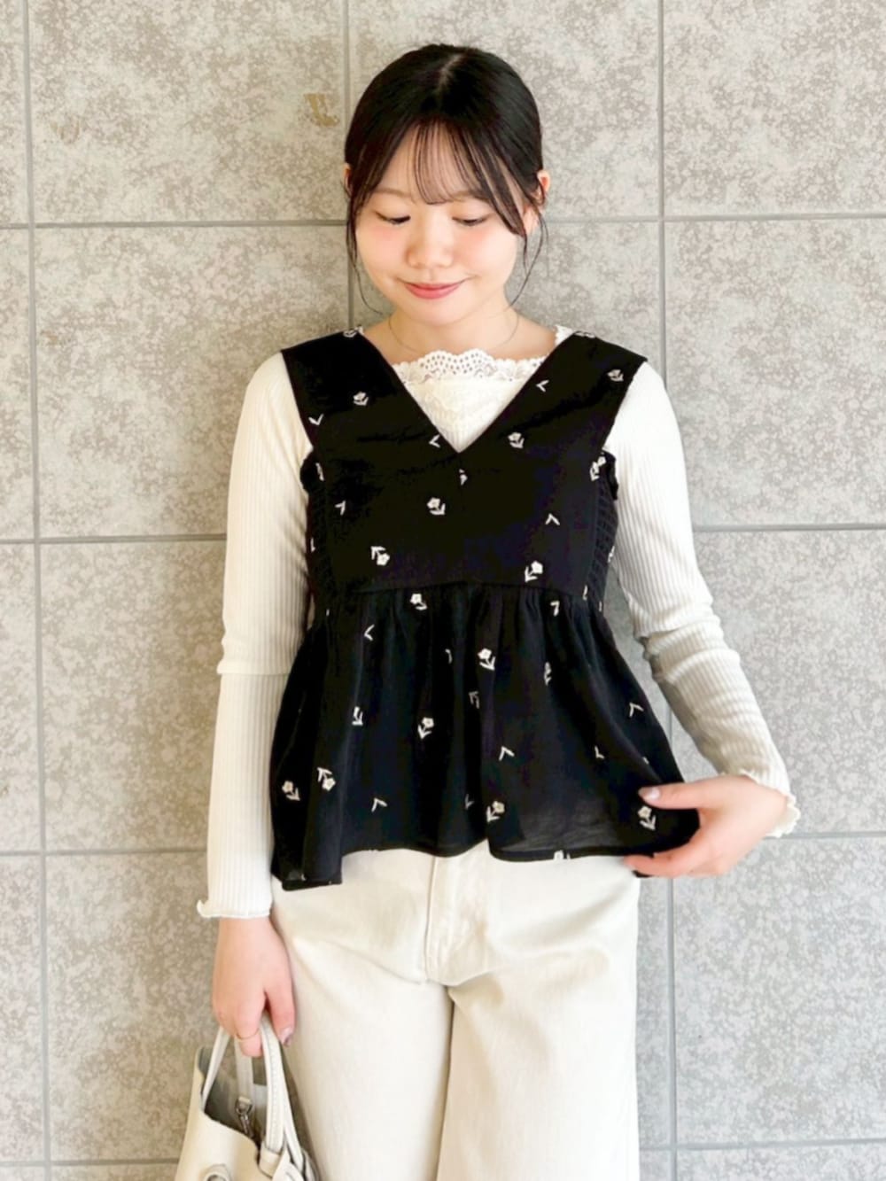 ホワイト系のハンドバッグ、ホワイト系のTシャツ/カットソー、ブラック系のキャミソールを着用したレディースの春コーディネートの2枚目の写真