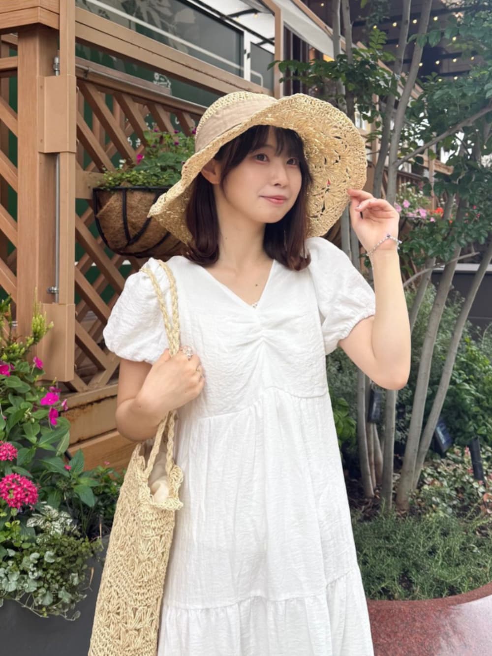 ホワイト系のかごバッグ、ホワイト系のワンピース、ベージュ系のハットを着用したレディースの夏コーディネートの2枚目の写真