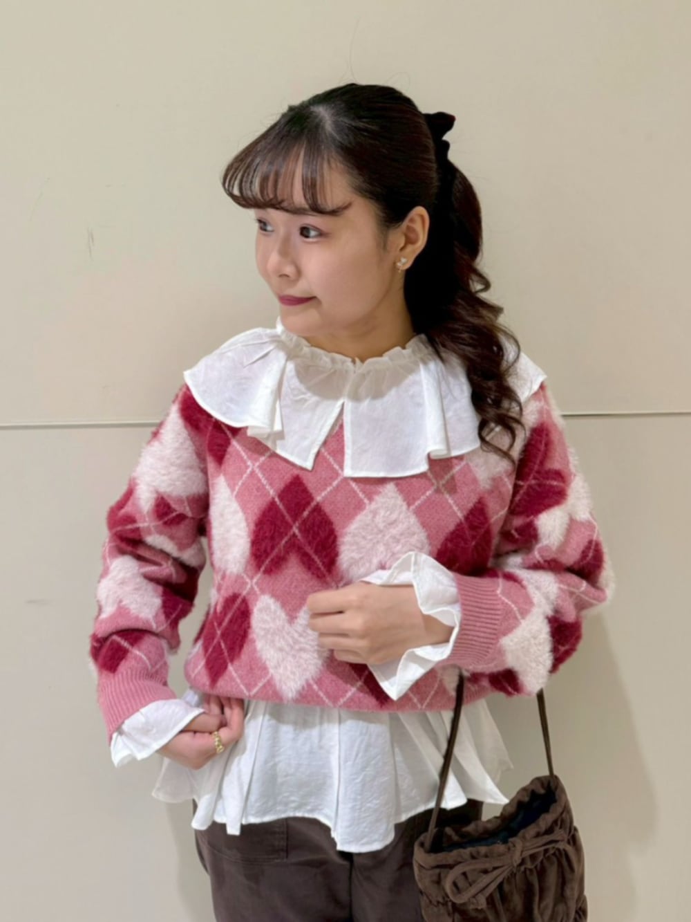 ブラウン系のその他パンツ、ホワイト系のシャツ/ブラウス、レッド系のニット/セーターを着用したレディースの秋コーディネートの2枚目の写真