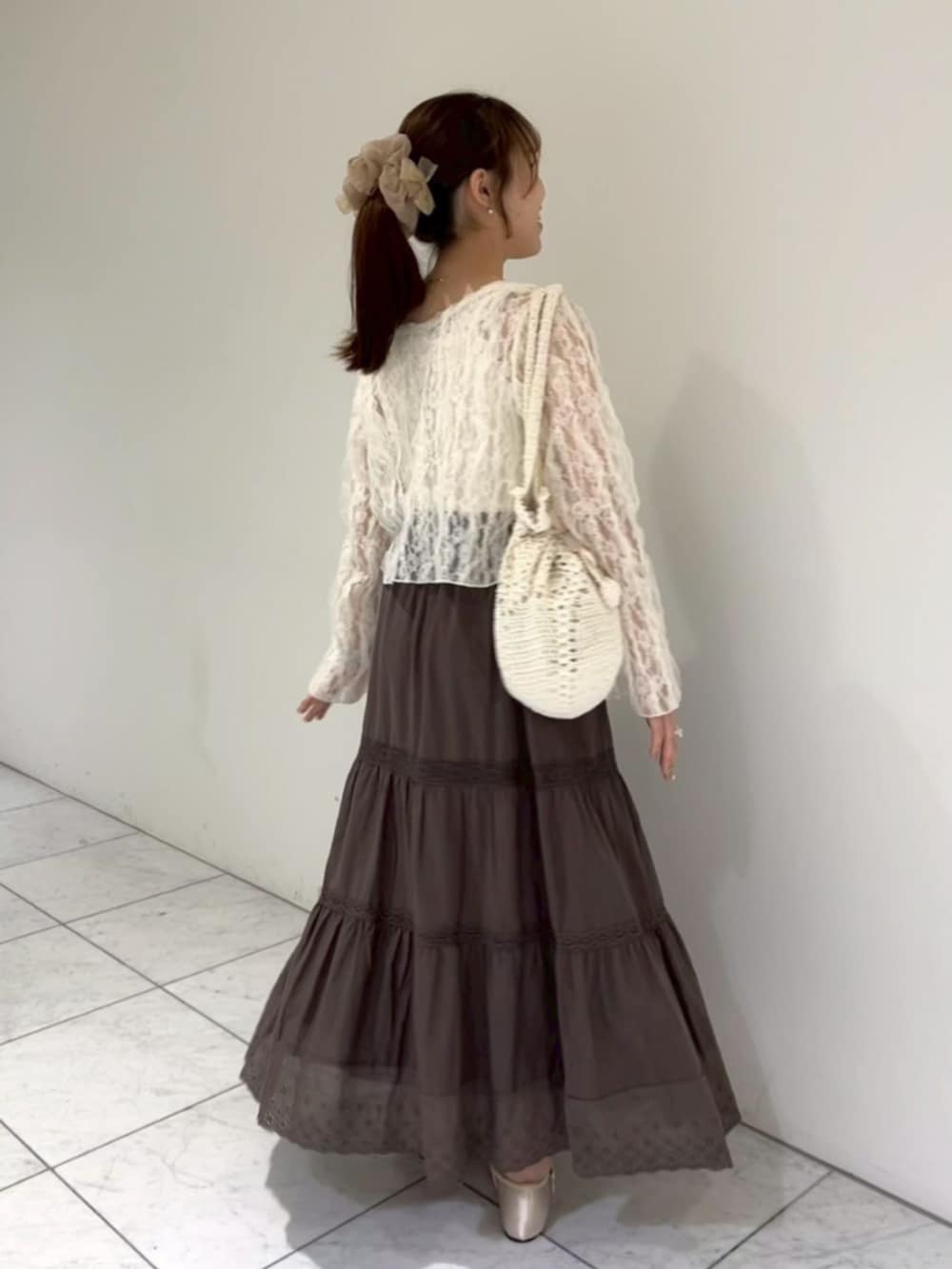 ホワイト系のキャミソール、ホワイト系のキャミソール、ホワイト系のショルダーバッグを着用したレディースの夏コーディネートの2枚目の写真