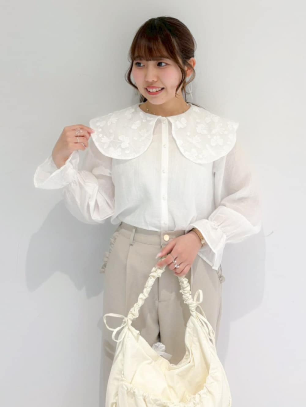 ホワイト系のショルダーバッグ、ホワイト系のシャツ/ブラウス、ベージュ系のその他パンツを着用したレディースの春コーディネートの2枚目の写真