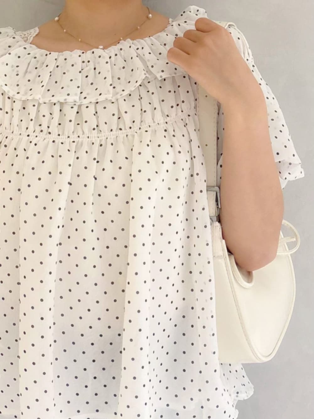 ブルー系のデニムパンツ、ホワイト系のショルダーバッグ、ホワイト系のシャツ/ブラウスを着用したレディースの夏コーディネートの3枚目の写真