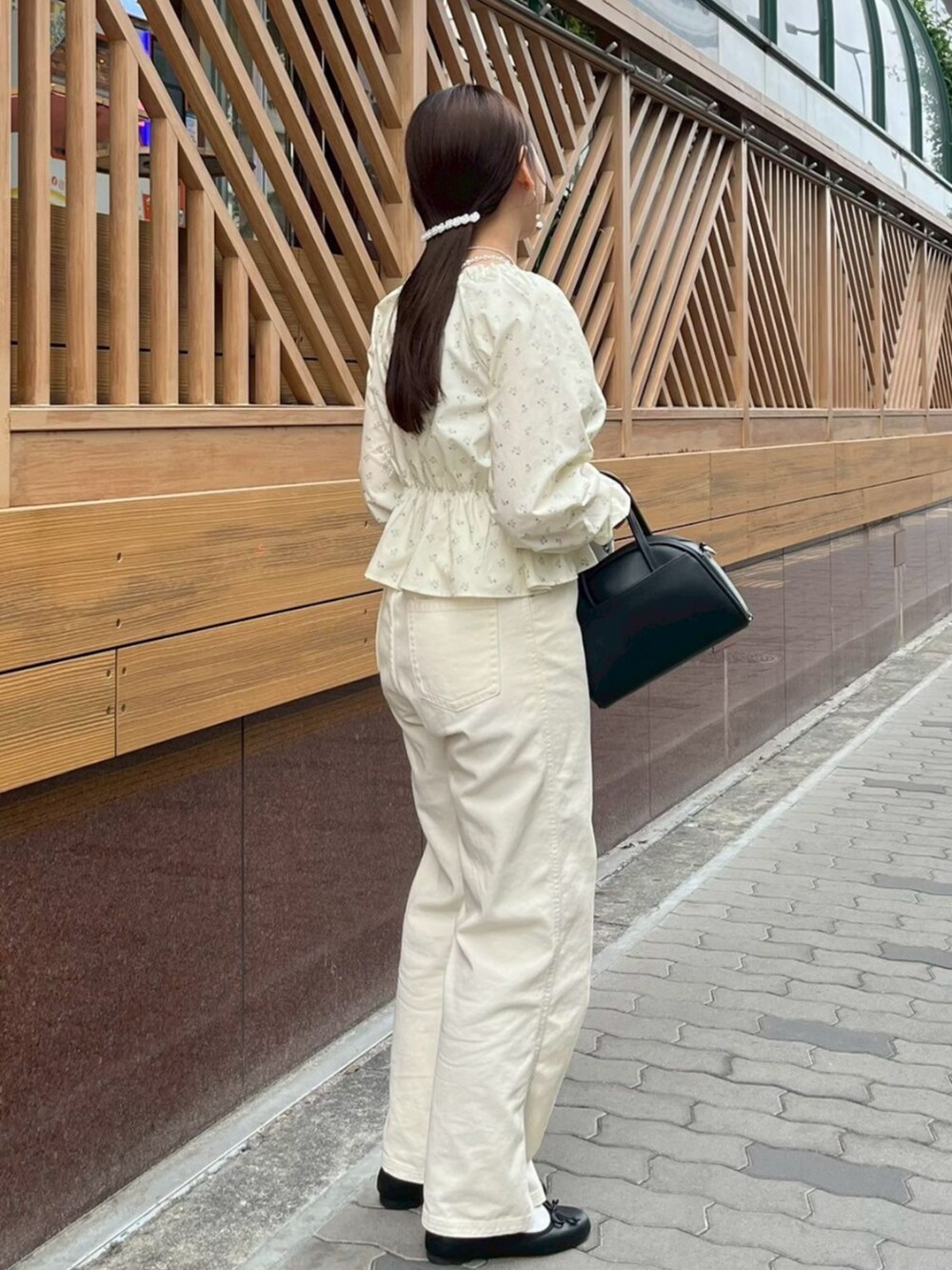 ホワイト系のデニムパンツ、ブラック系のハンドバッグ、ホワイト系のシャツ/ブラウスを着用したレディースの春コーディネートの2枚目の写真