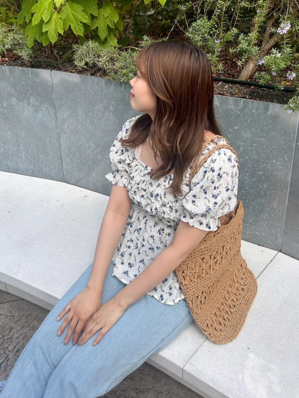 ブルー系のシャツ/ブラウス、ベージュ系のトートバッグを着用したレディースの春コーディネートの2枚目の写真