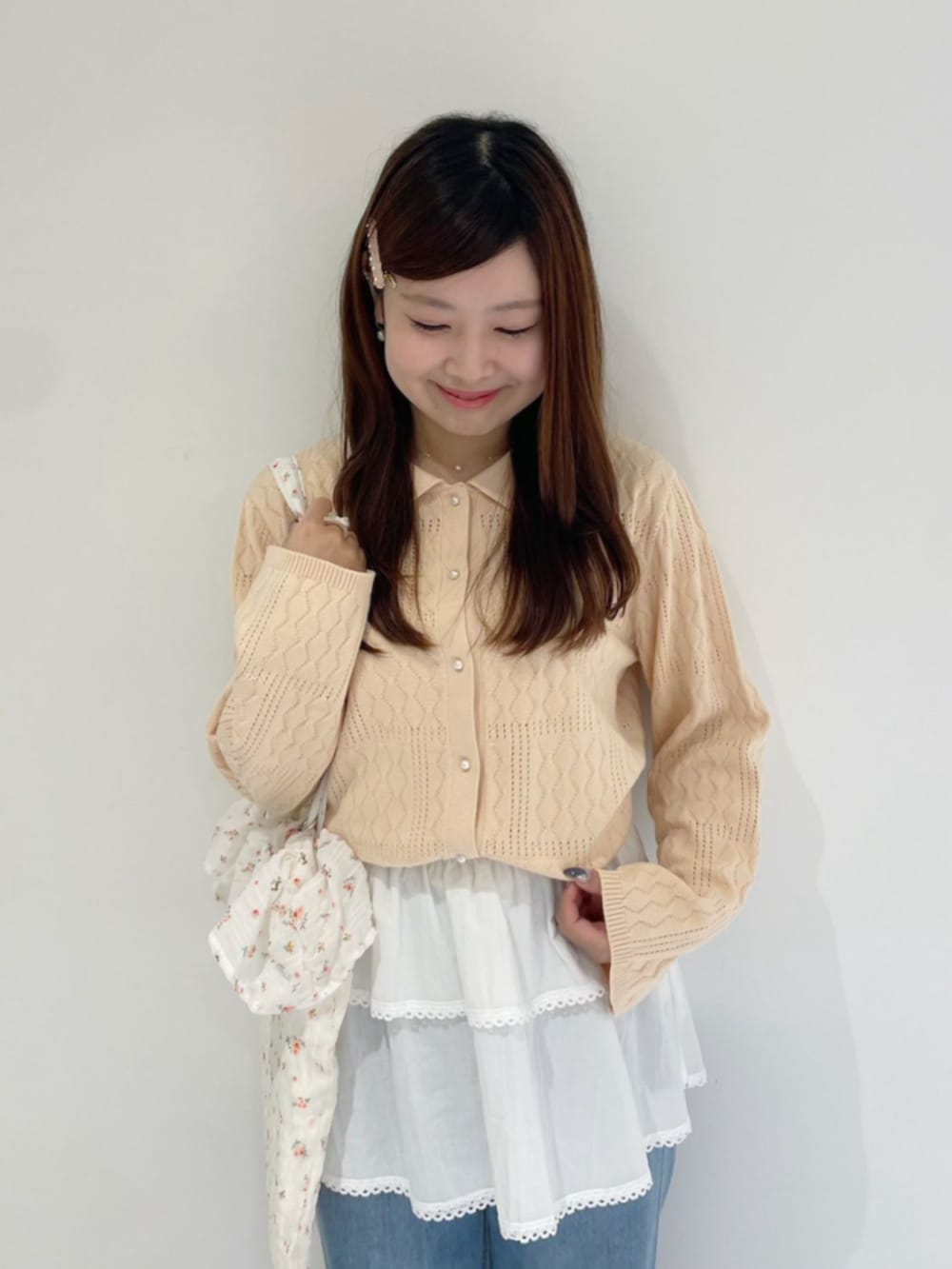 ブルー系のデニムパンツ、ホワイト系のチューブトップ、ホワイト系のトートバッグを着用したレディースの夏コーディネートの2枚目の写真