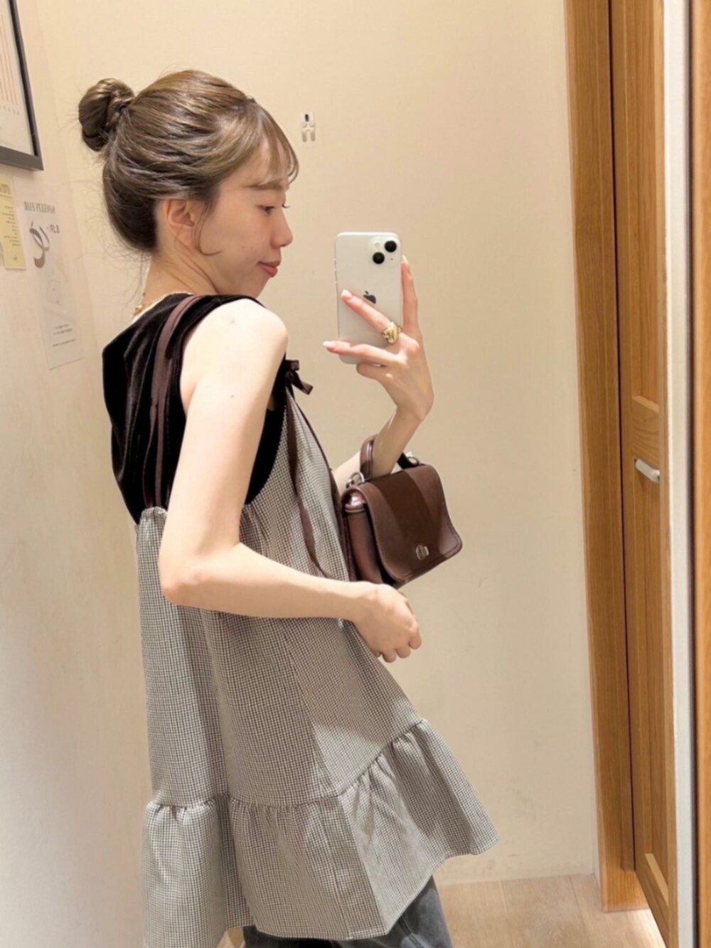 ブラック系のデニムパンツ、ブラウン系のワンピースを着用したレディースの秋コーディネートの2枚目の写真