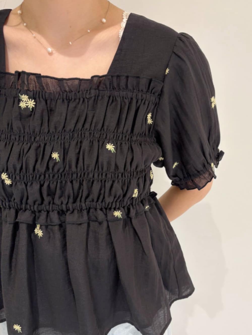 ホワイト系のショルダーバッグ、ブルー系のデニムパンツ、ブラック系のシャツ/ブラウスを着用したレディースの春コーディネートの3枚目の写真