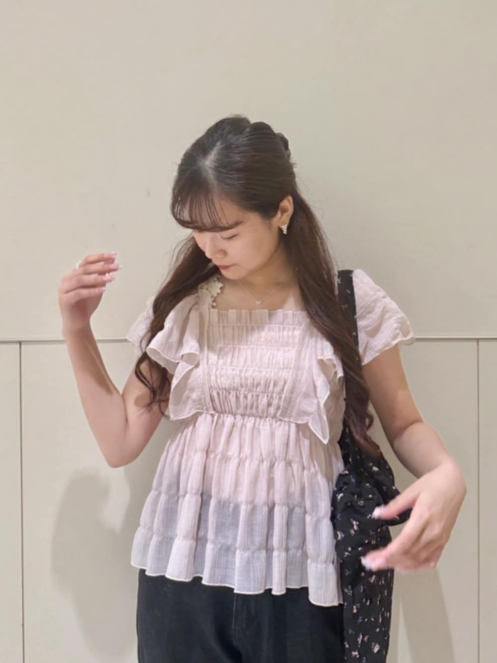 ブラック系のデニムパンツ、ピンク系のシャツ/ブラウス、ブラック系のトートバッグを着用したレディースの夏コーディネートの2枚目の写真