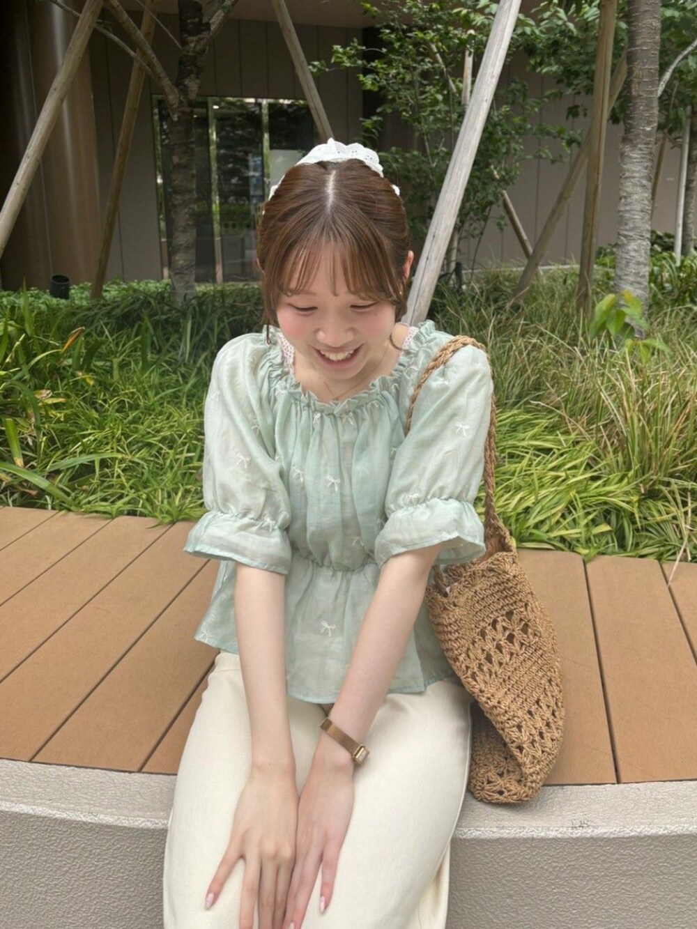 ホワイト系のデニムパンツ、グリーン系のシャツ/ブラウス、ベージュ系のトートバッグを着用したレディースの夏コーディネートの2枚目の写真