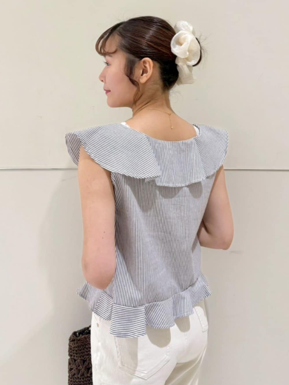 ブラウン系のかごバッグ、ブラウン系のシャツ/ブラウス、ホワイト系のデニムパンツを着用したレディースの夏コーディネートの3枚目の写真