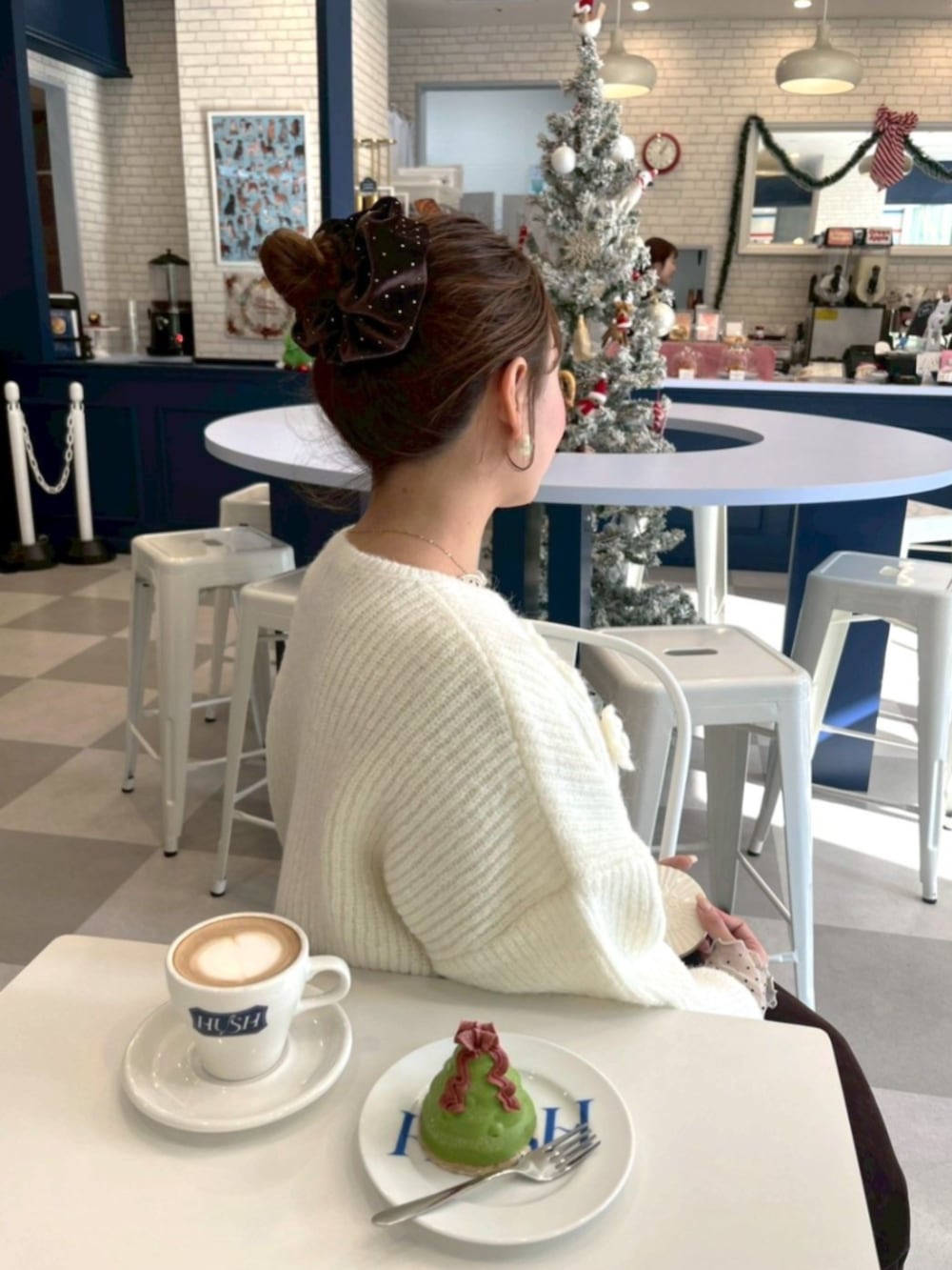 ホワイト系のニット/セーター、ブラウン系のシュシュを着用したレディースの冬コーディネートの2枚目の写真