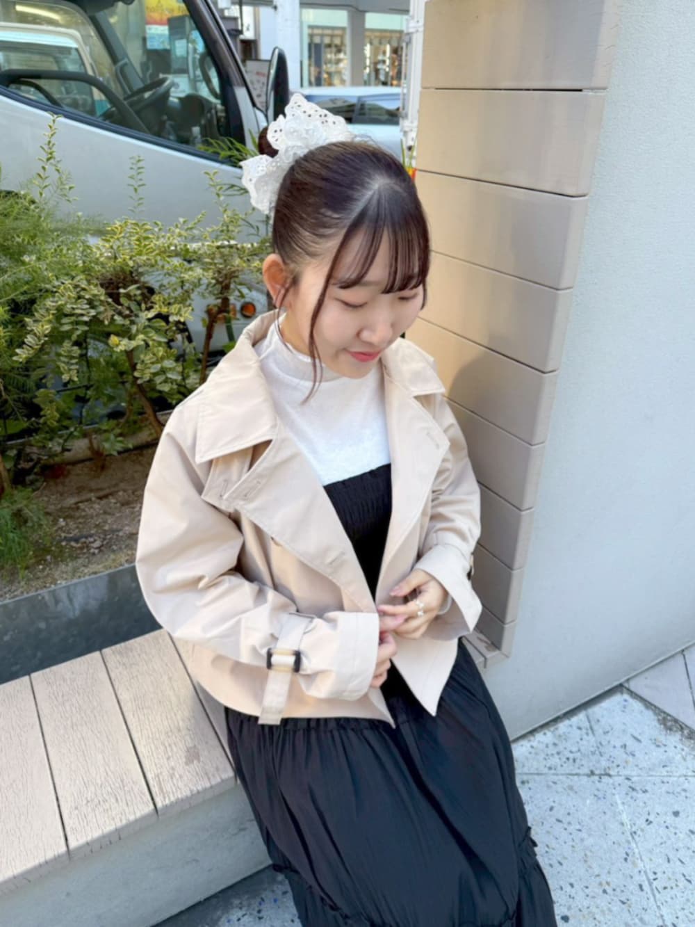 ベージュ系のトレンチコート、ホワイト系のTシャツ/カットソー、ブラック系のワンピースを着用したレディースの冬コーディネートの3枚目の写真