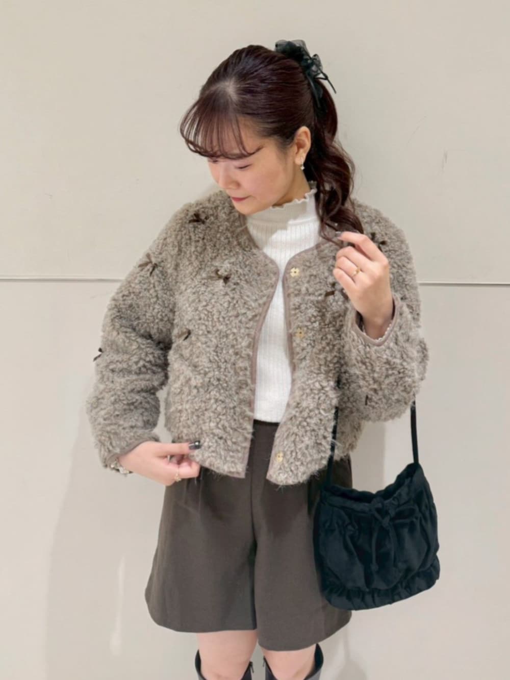 ホワイト系のニット/セーター、ブラウン系のその他パンツ、ブラック系のショルダーバッグを着用したレディースの秋コーディネートの2枚目の写真