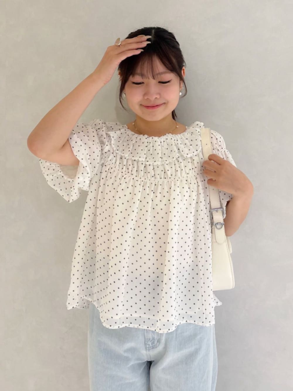 ブルー系のデニムパンツ、ホワイト系のショルダーバッグ、ホワイト系のシャツ/ブラウスを着用したレディースの夏コーディネートの2枚目の写真