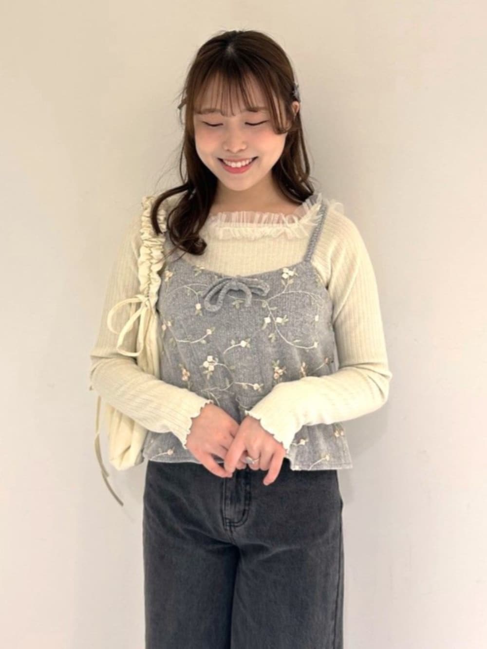 ホワイト系のショルダーバッグ、ホワイト系のTシャツ/カットソー、グレー系のキャミソールを着用したレディースの冬コーディネートの2枚目の写真