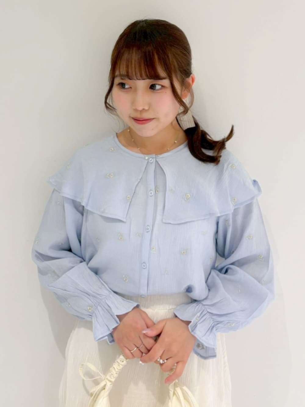 ホワイト系のショルダーバッグ、ホワイト系のスカート、ブルー系のシャツ/ブラウスを着用したレディースの春コーディネートの2枚目の写真