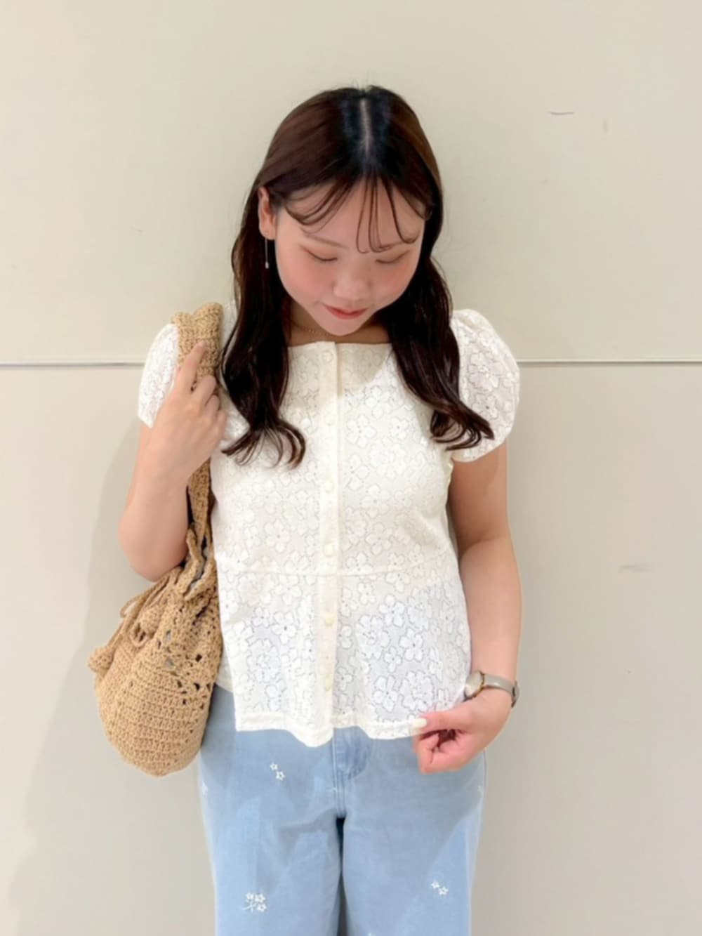ブラウン系のショルダーバッグ、ブルー系のデニムパンツ、ホワイト系のシャツ/ブラウスを着用したレディースの夏コーディネートの2枚目の写真