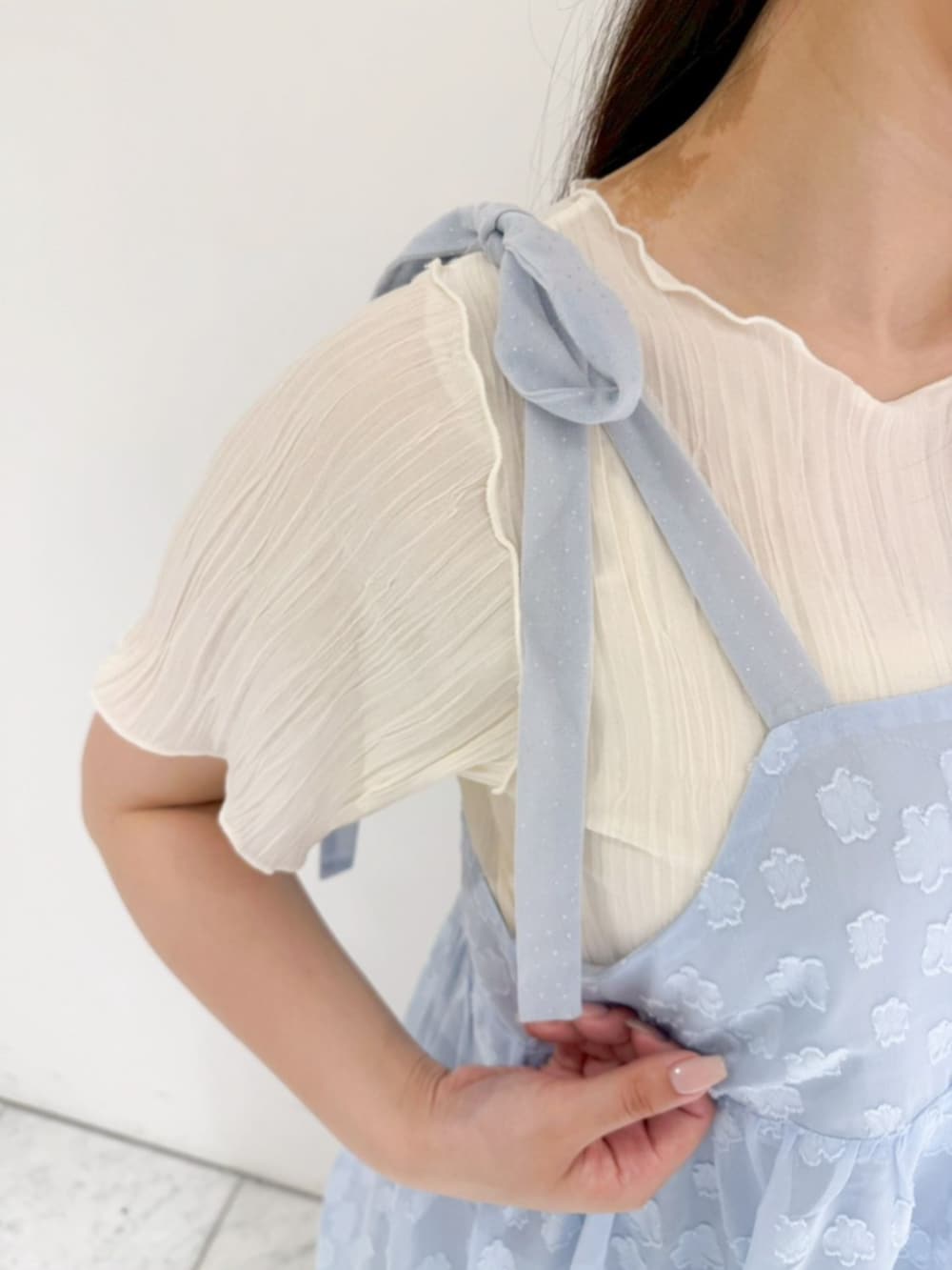 ホワイト系のTシャツ/カットソー、ブラック系のデニムパンツ、ホワイト系のショルダーバッグを着用したレディースの春コーディネートの3枚目の写真